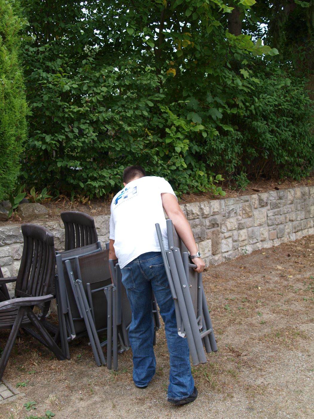 Gartenmöbel werden für die Gartenpflege beiseitegeräumt